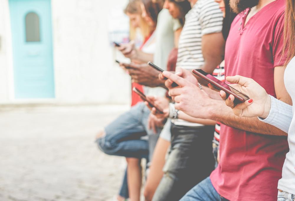 Group of friends watching smart mobile phones - Teenagers addiction to new technology trends - Concept of youth, tech, social and friendship - Focus on close-up phone