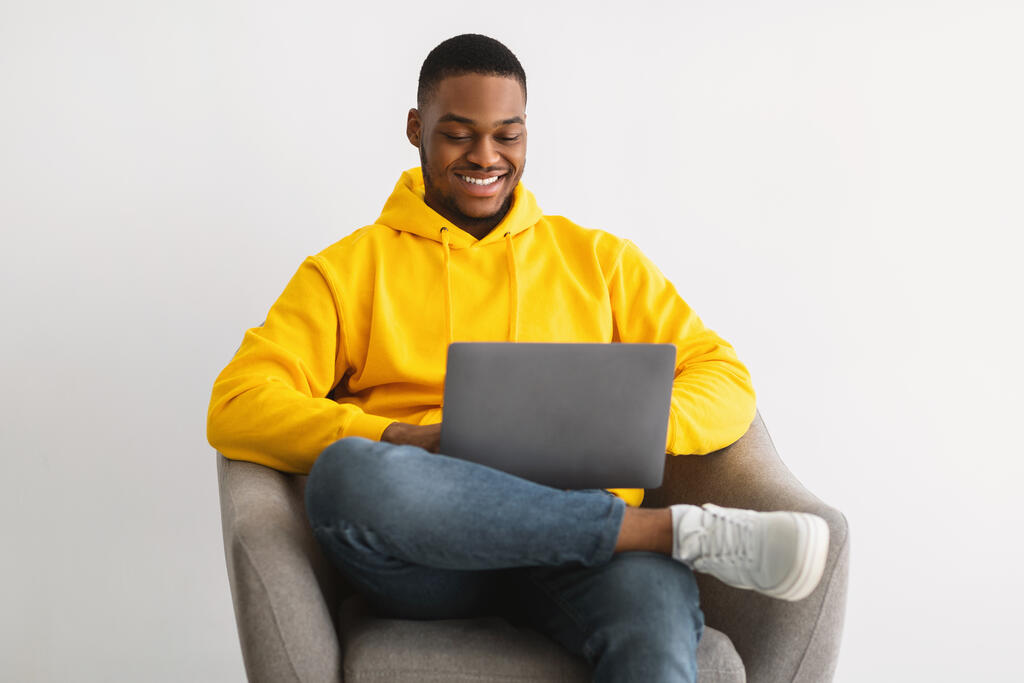 Man sitting in chair using laptop