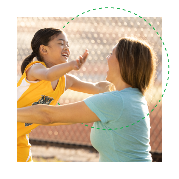 Young athlete smiling and running into the open arms of parent