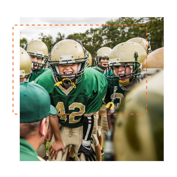 Youth football team huddled with coach